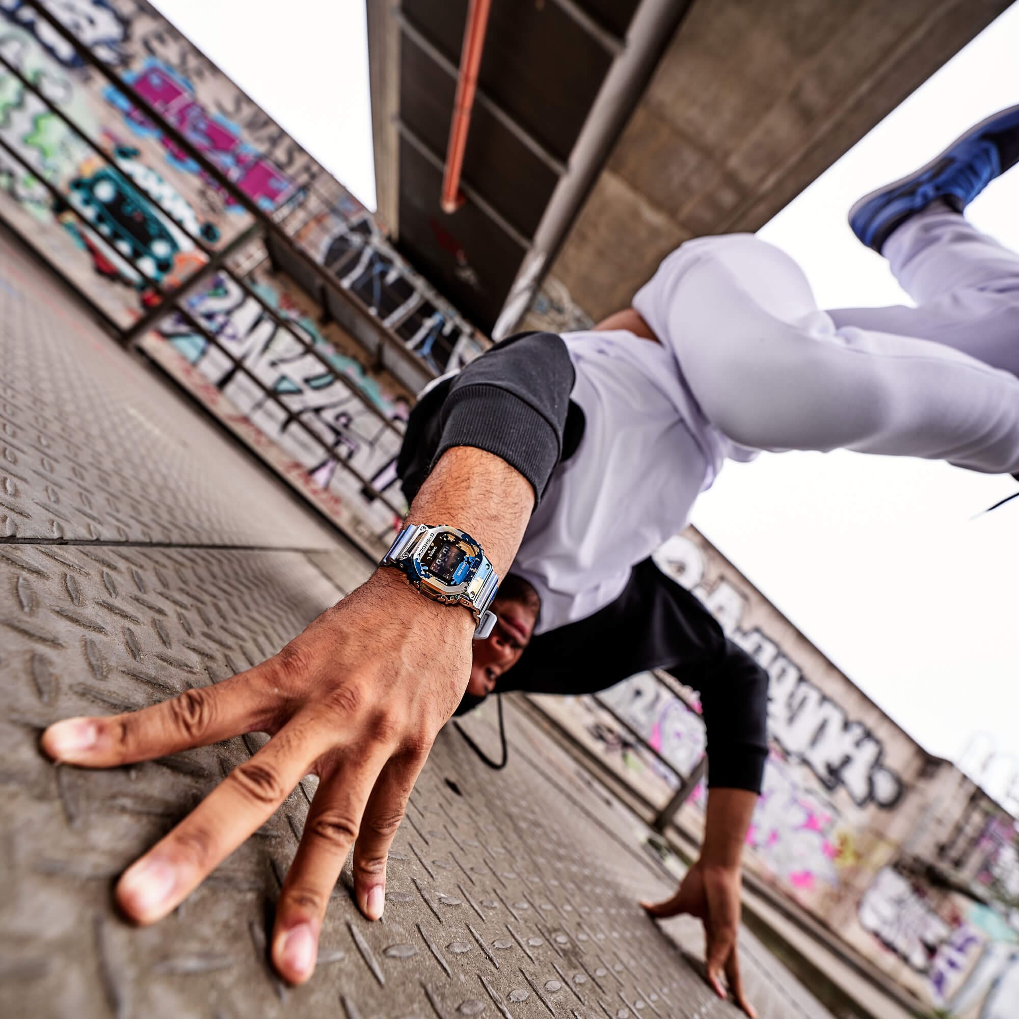 Een breakdancer doet een handstand, in focus is zijn pols waarop de G-SHOCK GM-5600SS-1ER.