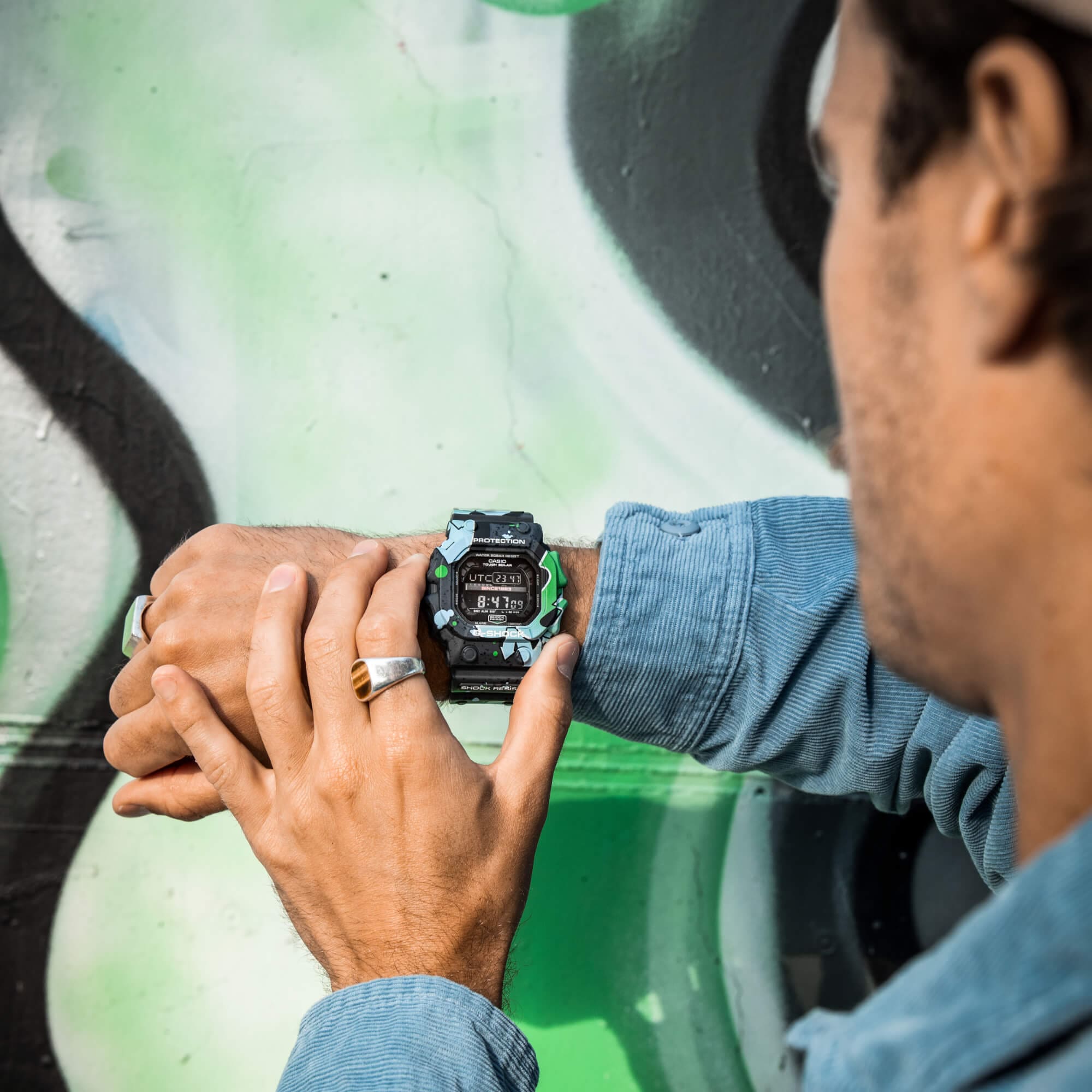 Een persoon drukt op de knoppen van de G-SHOCK GX-56SS-1ER die hij om zijn pols draagt.