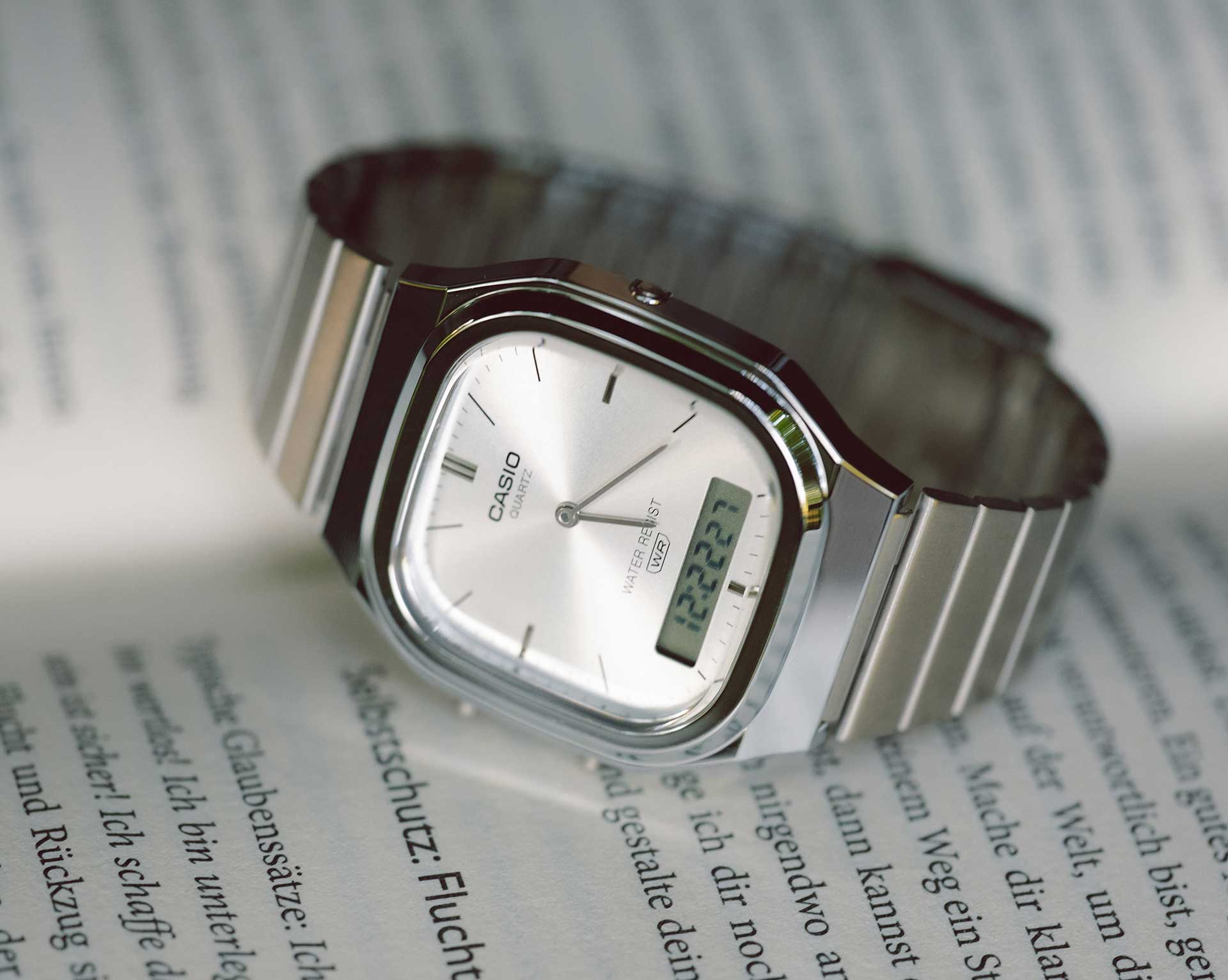 O relógio retro-moderno AQ-240 da coleção CASIO Vintage, com bracelete prateada e mostrador analógico quadrado.