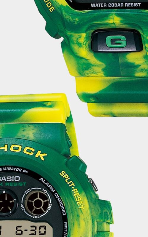 Detalhe da caixa verde e amarela do relógio de pulso Casio G-Shock DW-6900MC-3 e grande plano da bracelete verde e amarela