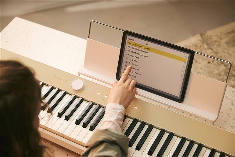 Uma imagem de uma pessoa a utilizar o tablet ligado ao piano