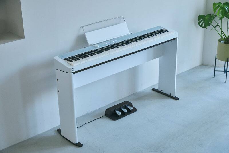 Hình ảnh một cây đàn piano trên chân đế và bộ 3 bàn đạp có giắc nối